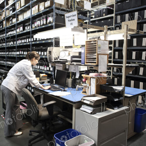 A caucasian female technician checking for parts on a desktop computer in a storage… A caucasian female technician checking for parts on a desktop computer in a storage…