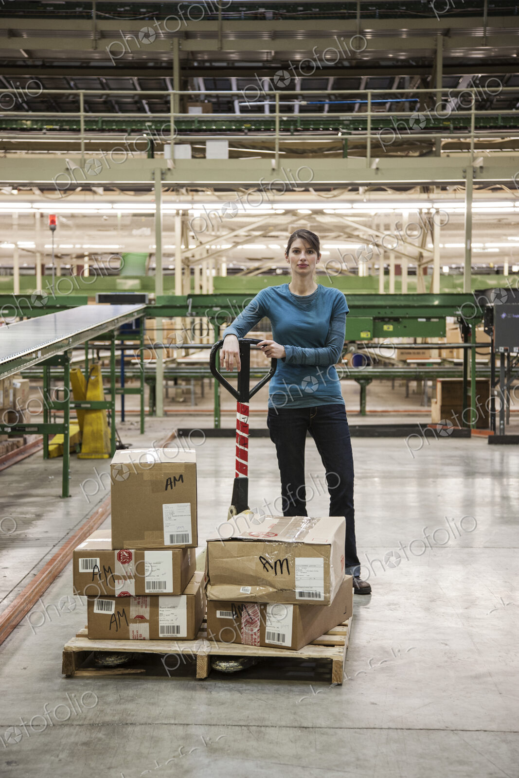 A caucasian female warehouse worker in a distribution warehouse.
