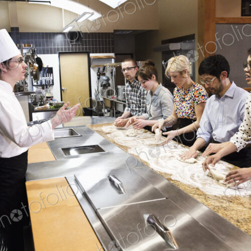 A caucasian male chef teaching a cooking class, multi ethnic group. A caucasian male chef teaching a cooking class, multi ethnic group.