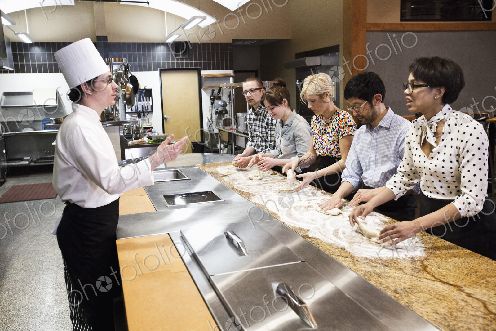 A caucasian male chef teaching a cooking class, multi ethnic group.