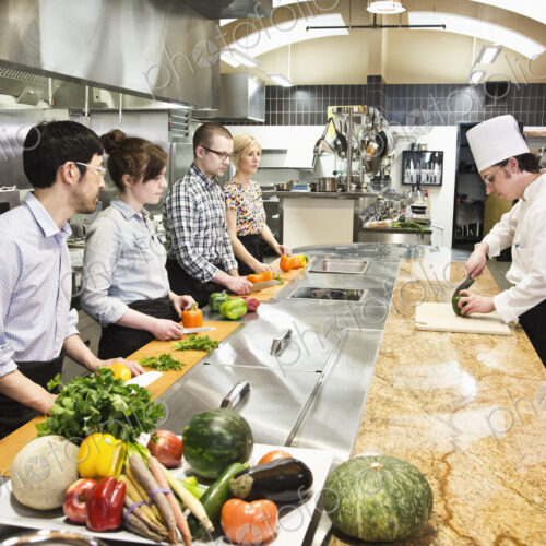 A caucasian male chef teaching a cooking class, multi ethnic group. A caucasian male chef teaching a cooking class, multi ethnic group.