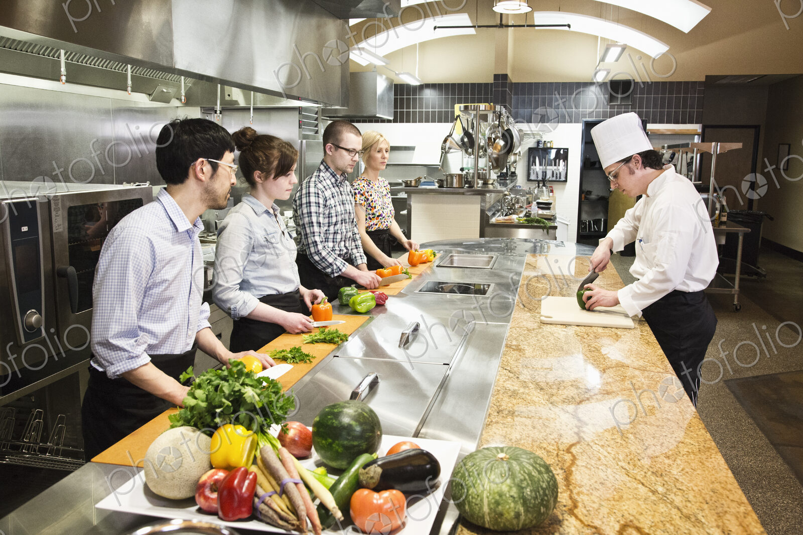 A caucasian male chef teaching a cooking class, multi ethnic group.