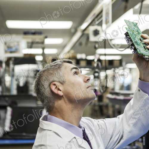 A caucasian male technician examining a circuit board in a technical research and… A caucasian male technician examining a circuit board in a technical research and…