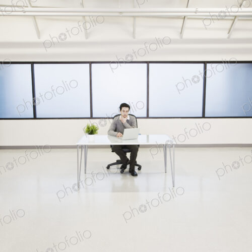 A caucasian man lab techncian working in the office of a computer server farm. A caucasian man lab techncian working in the office of a computer server farm.