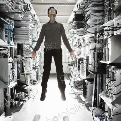 A caucasian man lab technician appearing to float through air in the aisle of a… A caucasian man lab technician appearing to float through air in the aisle of a…