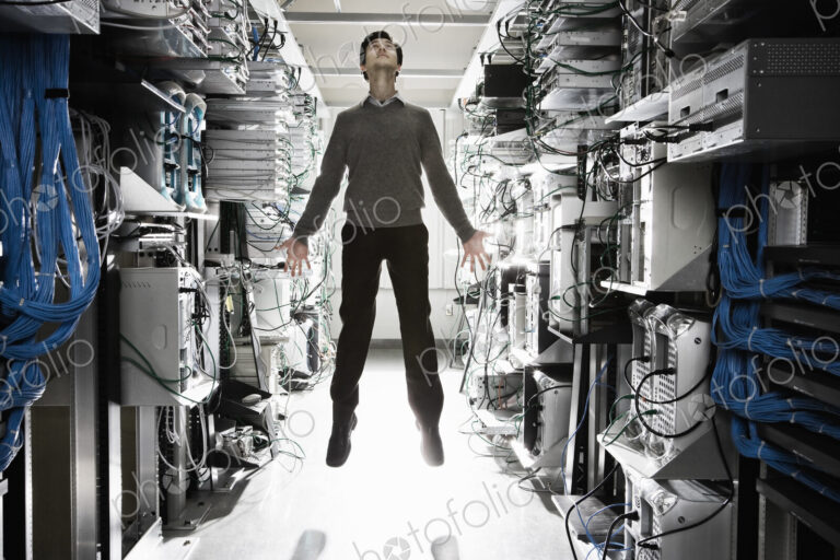 A caucasian man lab technician appearing to float through air in the aisle of a…