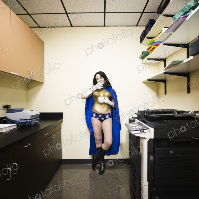 A caucasian woman office super hero takes a break and has snack.