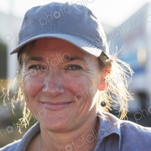 A caucasian woman truck driver near her truck parked in a parking lot of a truck stop. A caucasian woman truck driver near her truck parked in a parking lot of a truck stop.
