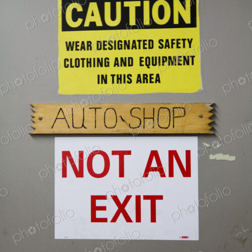 A caution warning sign on a door to an auto-shop, warning, Not An Exit, in red lettering. A caution warning sign on a door to an auto-shop, warning, Not An Exit, in red lettering.