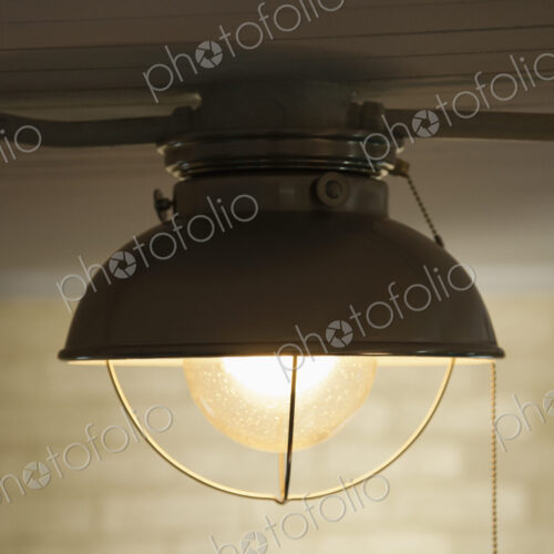 A ceiling light with a white lampshade, a glass shade and a light bulb. A ceiling light with a white lampshade, a glass shade and a light bulb.