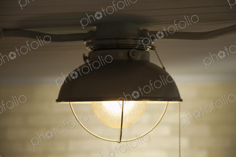 A ceiling light with a white lampshade, a glass shade and a light bulb.
