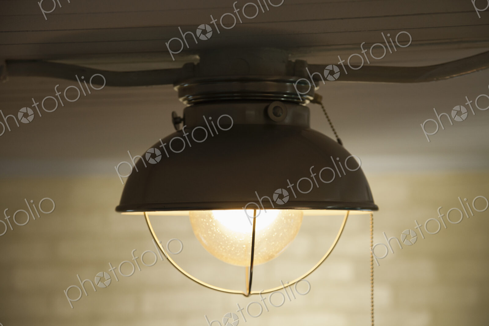 A ceiling light with a white lampshade, a glass shade and a light bulb.