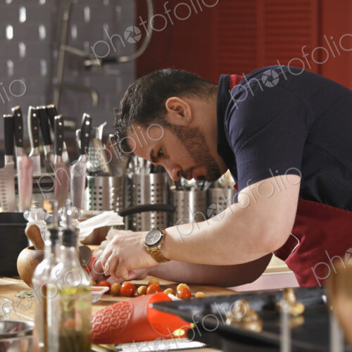 A chef bending and preparing food in a commercial kitchen