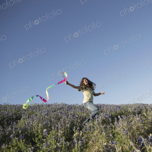 A child, a girl running with a paper streamer fluttering in the wind. A child, a girl running with a paper streamer fluttering in the wind.