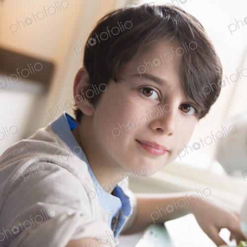 A child, a young boy with brown hair and brown eyes sitting at the family table. A child, a young boy with brown hair and brown eyes sitting at the family table.