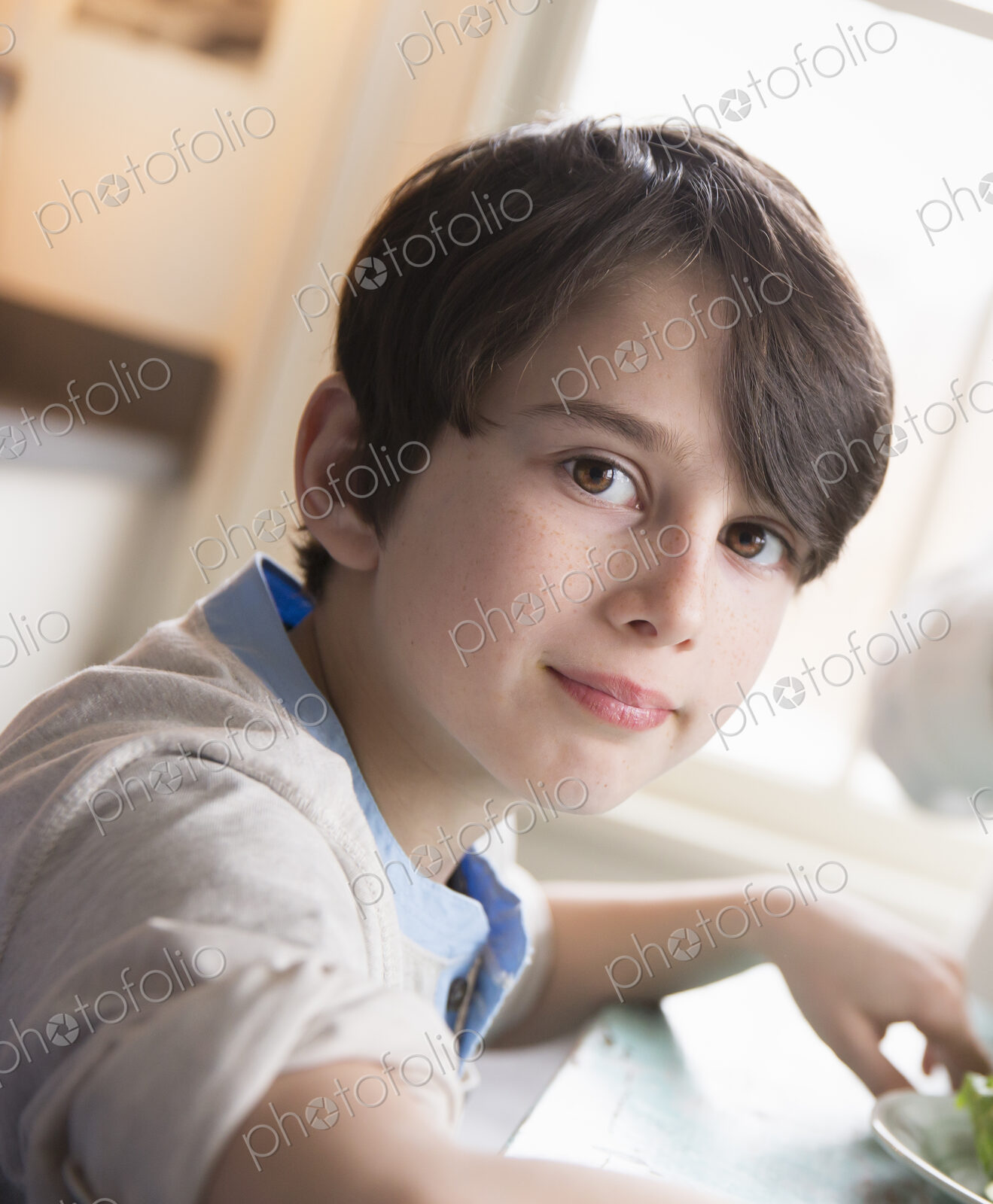 A child, a young boy with brown hair and brown eyes sitting at the family table.