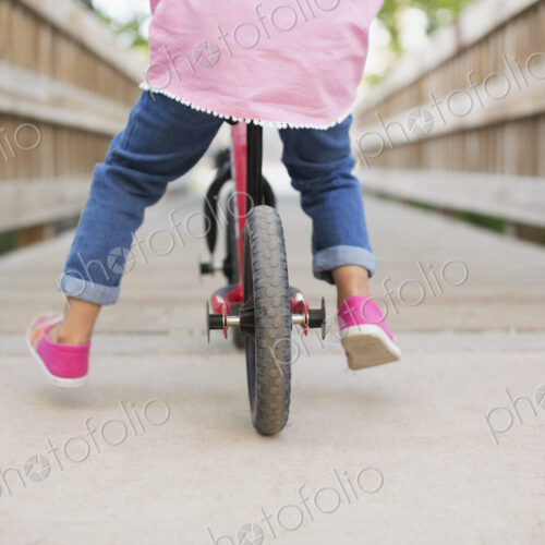 A child riding on a bicycle on a boardwalk. A child riding on a bicycle on a boardwalk.