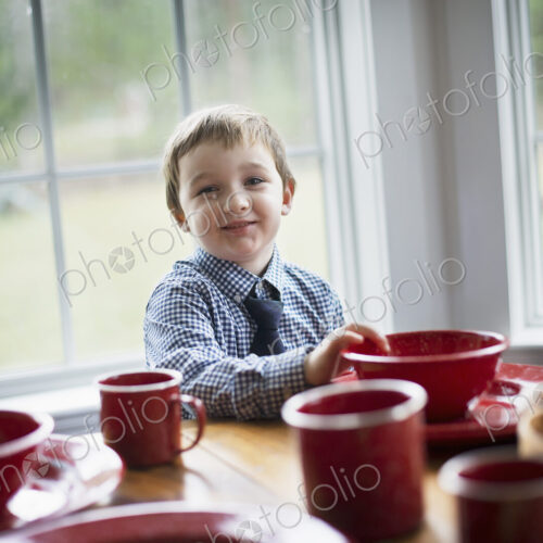 A child sitting at a table in a family home. A table laid for a meal. A child sitting at a table in a family home. A table laid for a meal.