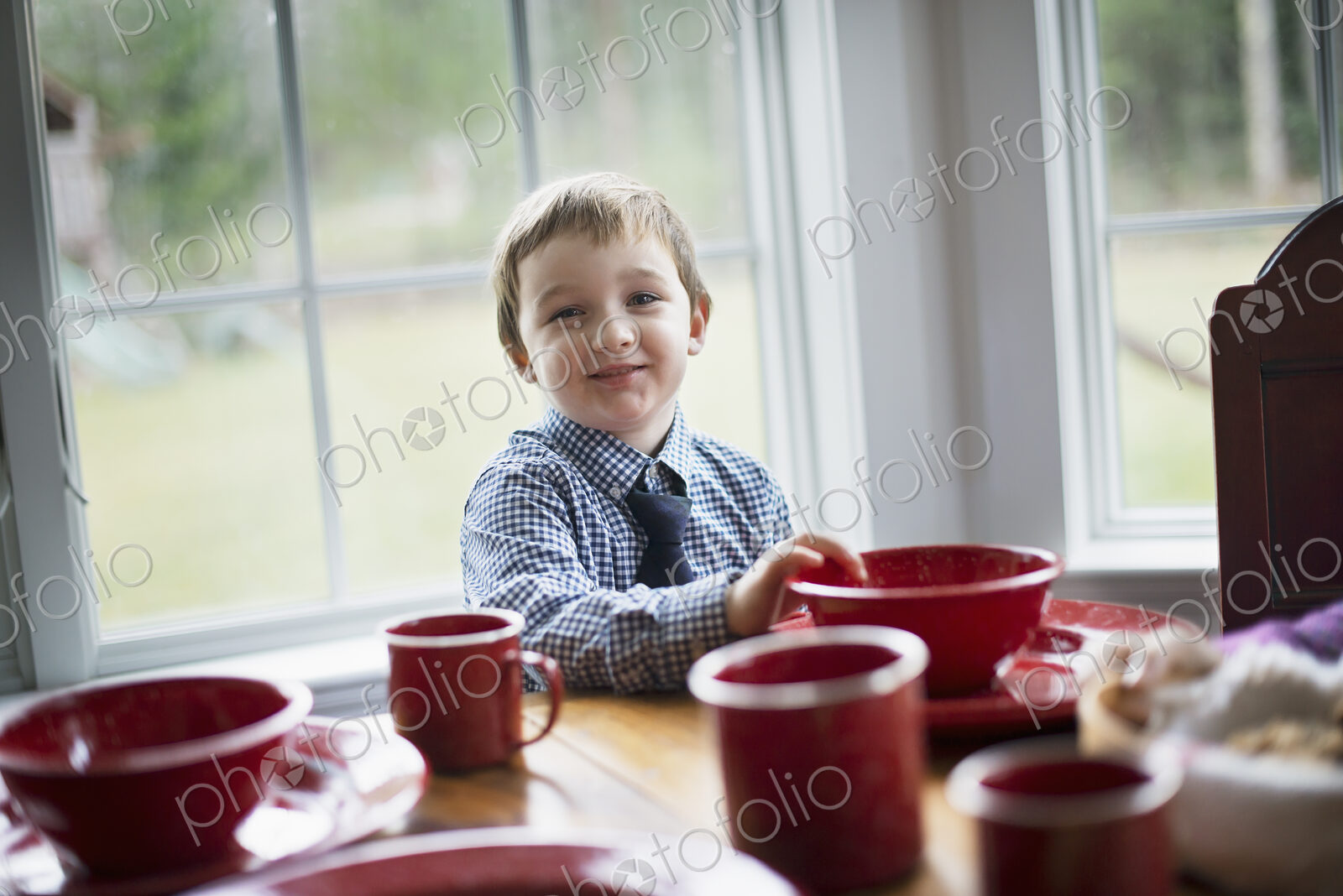 A child sitting at a table in a family home. A table laid for a meal.