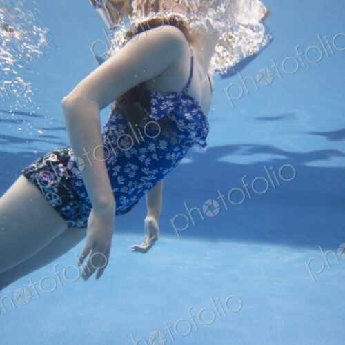 A child swimming under water in a swimming pool. A child swimming under water in a swimming pool.