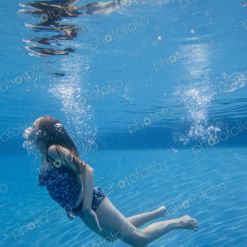 A child swimming under water in a swimming pool. A child swimming under water in a swimming pool.