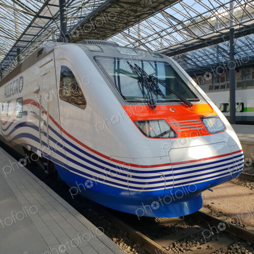 A city railway station, a train at a platform. A city railway station, a train at a platform.