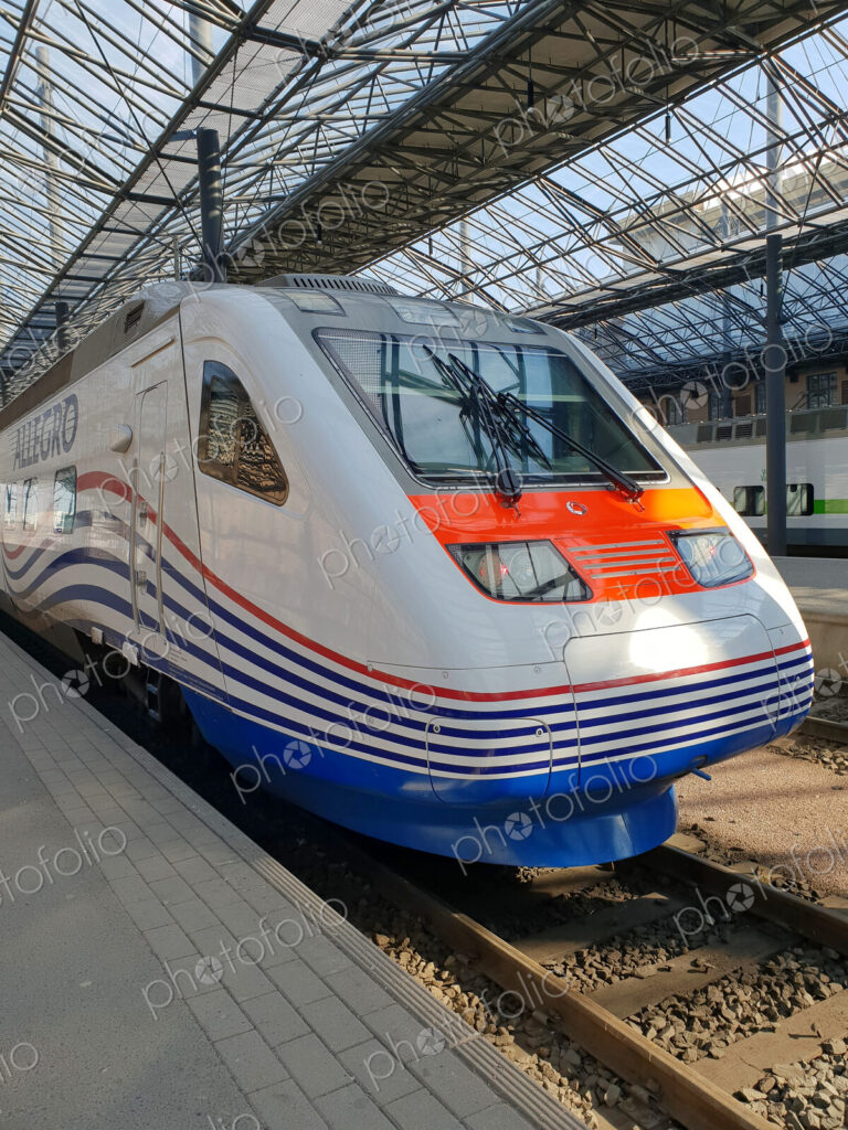 A city railway station, a train at a platform.