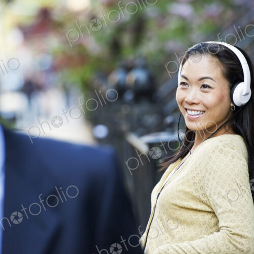 A city street with steps up to the brownstone buildings. A woman wearing music… A city street with steps up to the brownstone buildings. A woman wearing music…