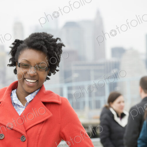 A cityscape, view to Manhattan from Brooklyn. Four people, two in the background…