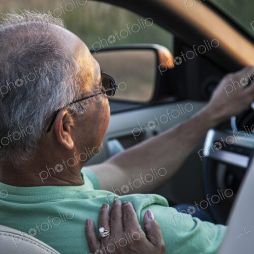 A closeup of a wife's hand on the shoulder of her husband driving a convertible sports… A closeup of a wife's hand on the shoulder of her husband driving a convertible sports…