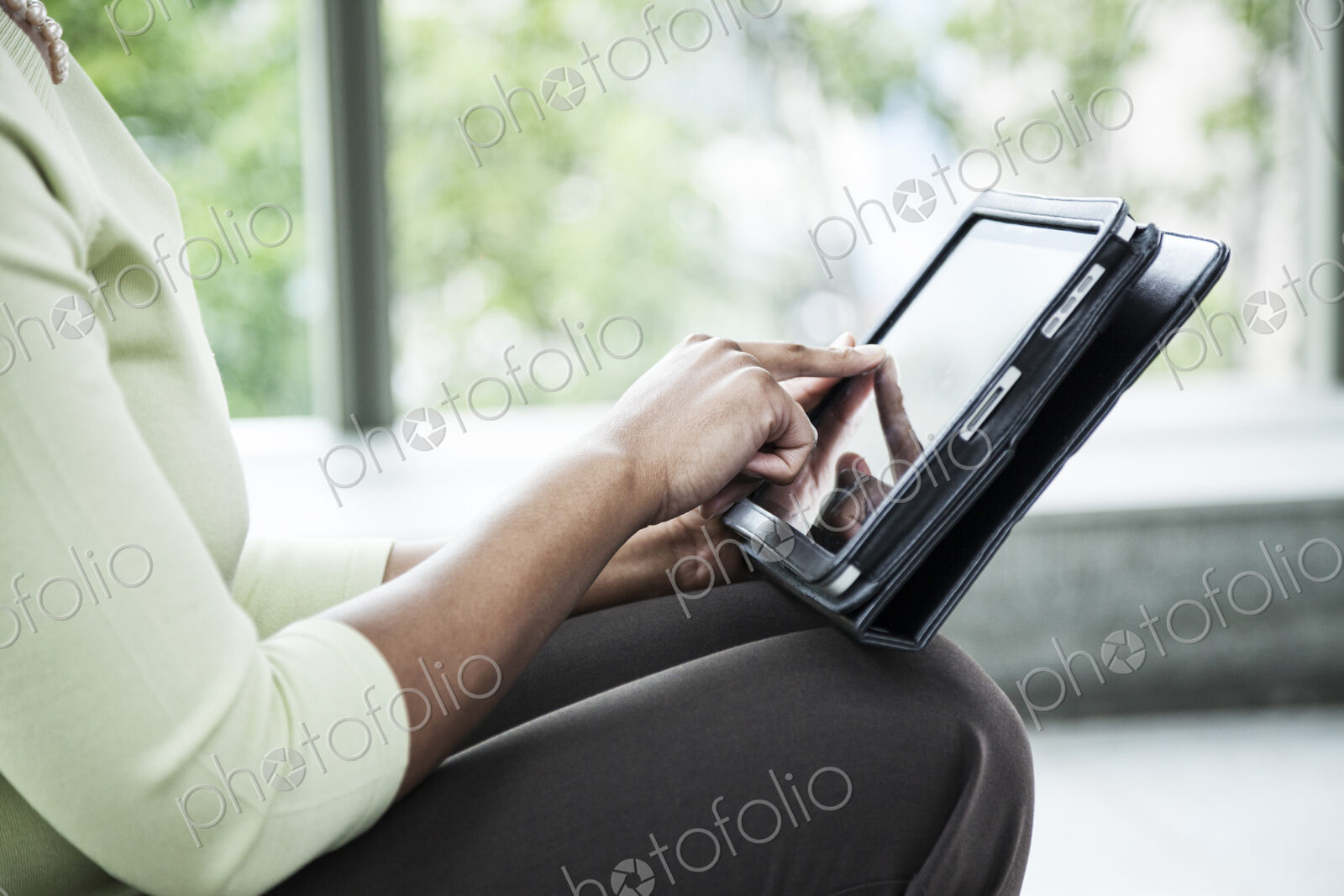 A closeup of the hands of a black businesswoman working on a ntoebook computer.