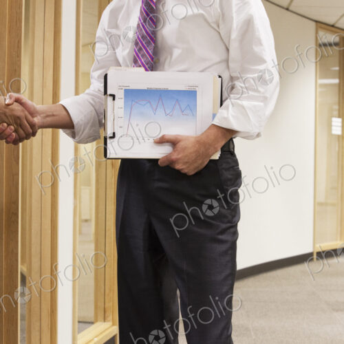 A closeup view of two business people shaking hands in an office space. A closeup view of two business people shaking hands in an office space.