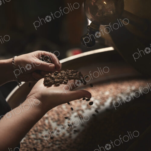A coffee shop. A person holding a handful of fresh coffee beans. A coffee shop. A person holding a handful of fresh coffee beans.