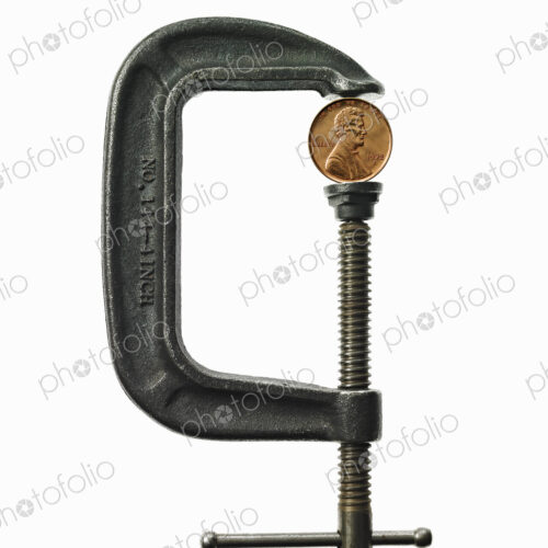 A coin in a clamp, conceptual shot.