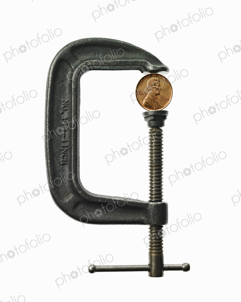 A coin in a clamp, conceptual shot.