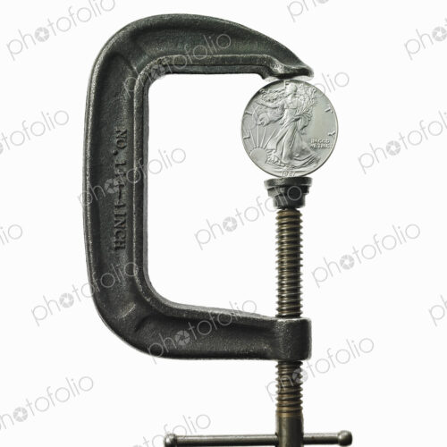 A coin in a clamp, conceptual shot.