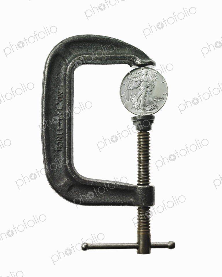 A coin in a clamp, conceptual shot.