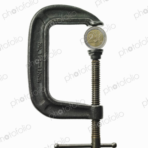 A coin in a clamp, conceptual shot.