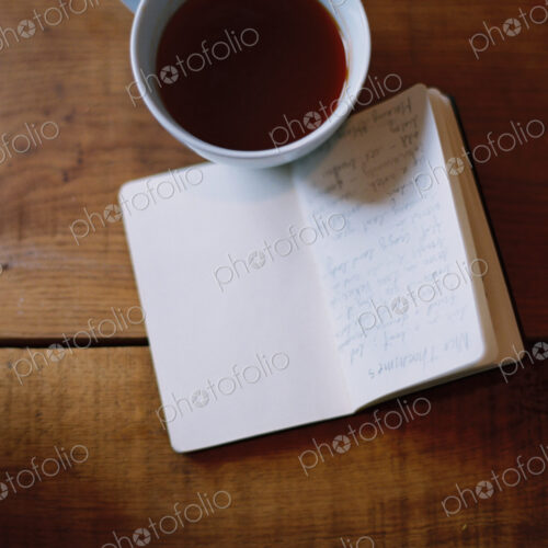 A cold cup of coffee and a handwritten journal.