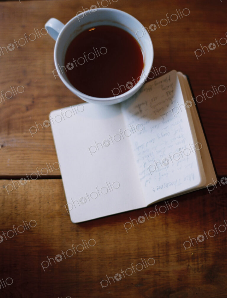 A cold cup of coffee and a handwritten journal.