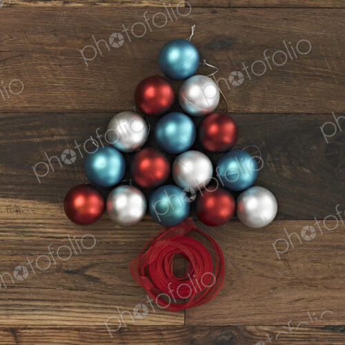 A collection of blue, red and silver ornaments arranged in a triangular shape on a… A collection of blue, red and silver ornaments arranged in a triangular shape on a…
