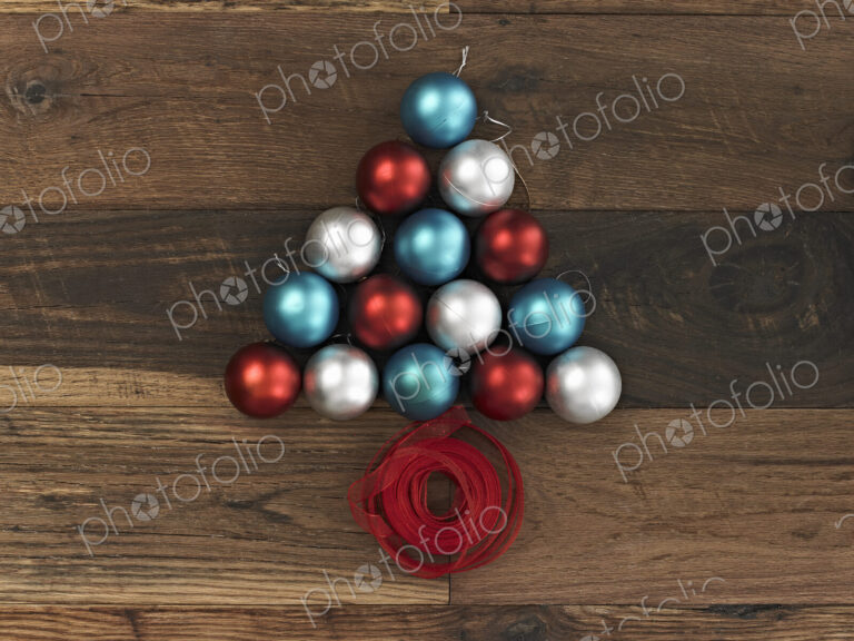 A collection of blue, red and silver ornaments arranged in a triangular shape on a…