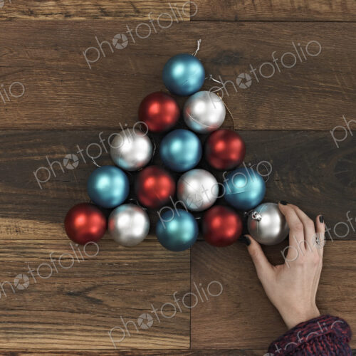 A collection of blue, red and silver ornaments arranged in a triangular shape on a… A collection of blue, red and silver ornaments arranged in a triangular shape on a…