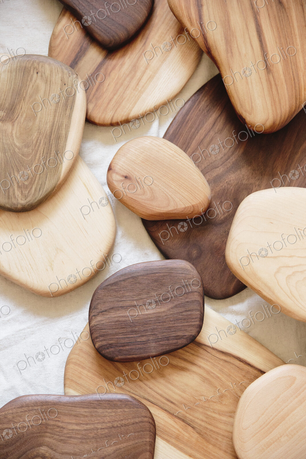 A collection of small smooth turned wooden objects of different colours and wood grain…