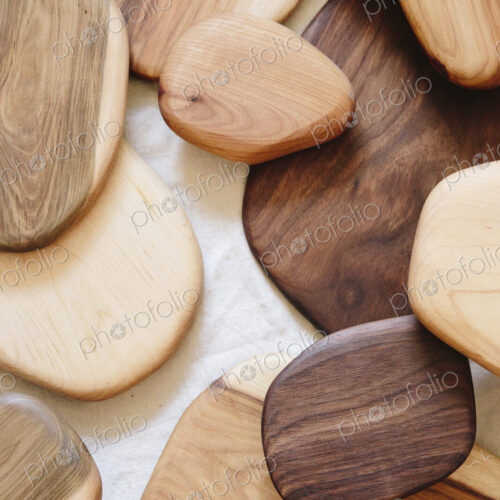 A collection of small smooth turned wooden objects of different colours and wood grain…