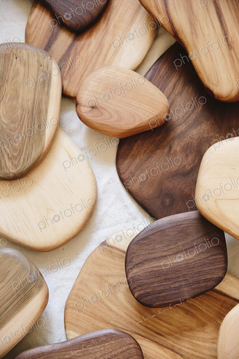 A collection of small smooth turned wooden objects of different colours and wood grain…