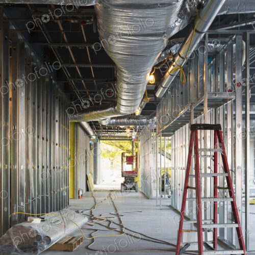 A commercial building under construction with roof ducts and light gauge steel framing.