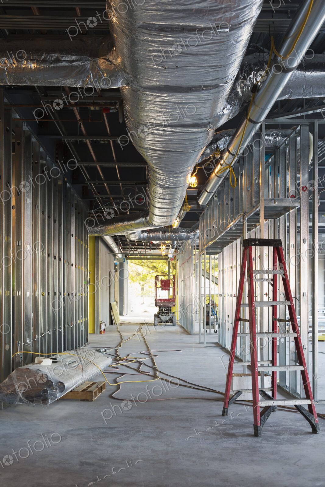 A commercial building under construction with roof ducts and light gauge steel framing.