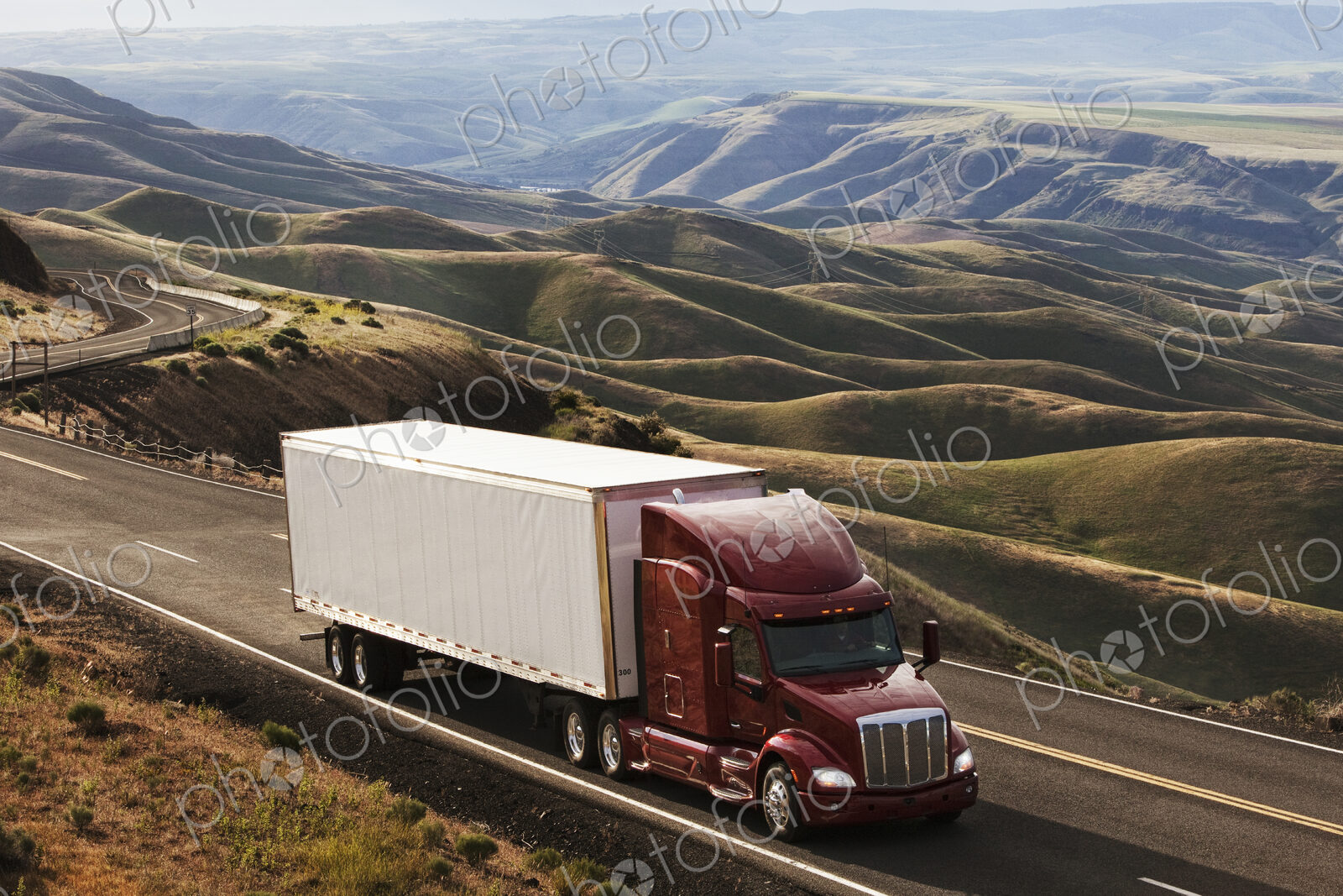 A commercial truck driving through the high rolling hills of southeastern Washington, USA