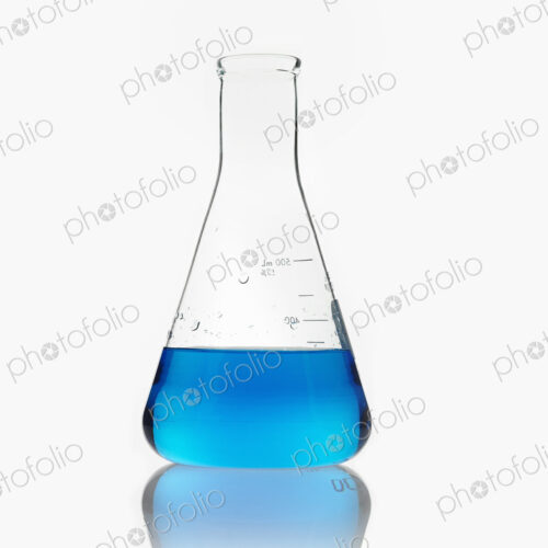 A conical scientific glassware flask partly filled with blue liquid. A conical scientific glassware flask partly filled with blue liquid.